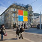 Das NZZ-Gebäude mit Leuten davon, einige Fenster sind mit dem Microsoft-Logo überdeckt. Quellen: NZZ-Gebäude, Falkenstrasse 11 (©NZZ); Microsoft-Logo (©Microsoft). Gesichtsanonymisierung und Collage: Marcel Waldvogel