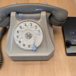 Ein Wählscheibentelefon und ein Handy auf einem Tisch