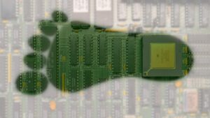 Eine alte Leiterplatte, überlagert von einem grünen Fussabdruck